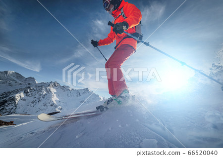 close up Skier rides on a snowy slope on a sunny day at sunset against the backdrop of the mountains. The concept of winter skiing close up Skier rides on a snowy slope on a sunny day at sunset against the backdrop of the mountains. The concept of winter skiing 66520040