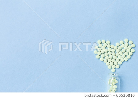 Group of yellow round tablets forms a heart shape Group of yellow round tablets forms a heart shape 66520816