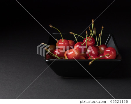 Organic cherries in a black bowl. Ripe berries on a black background. 66521136