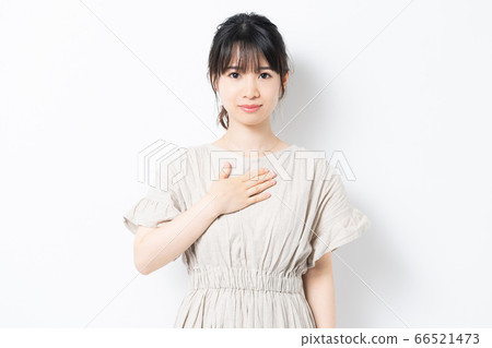 Young woman putting hands on chest 66521473