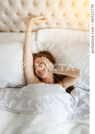 Happy young woomen in the bed. Girl spending time at home. Home vacation. Morning concept 66521776
