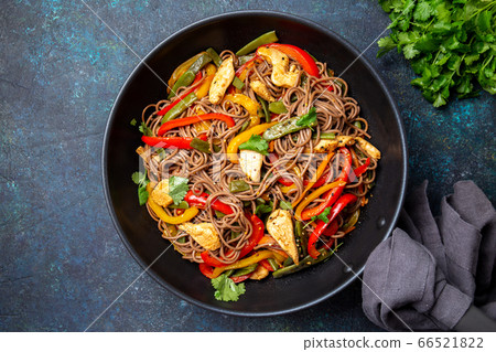 Japanese dish buckwheat soba noodles with chicken and vegetables carrot, bell pepper and green beans in wok on dark blue background 66521822
