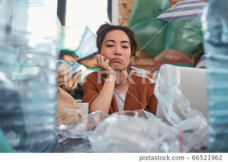 Slatternly young woman looking at camera with idle face 66521962