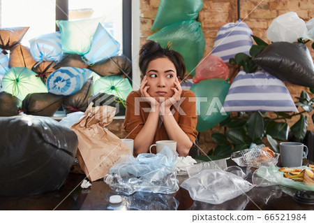 Asian woman spending time at her apartment full of rubbish Asian woman spending time at her apartment full of rubbish 66521984