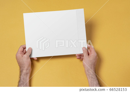 Male hands holding an A4 paper envelope mock-up 66528153