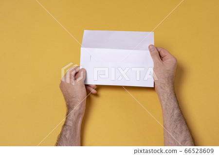 Male hand holding a letterhead paper envelope 66528609