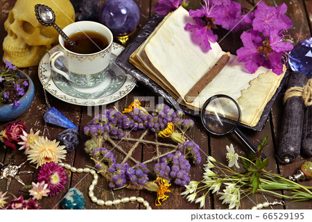 Pentagram with dry flowers, open diary and cup of coffee on witch table. Esoteric, wicca and occult background with magic objects, fortune telling and divination ritual, Halloween mystic background.  66529195