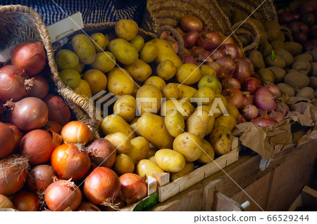 Onions and potatoes on market counter 66529244