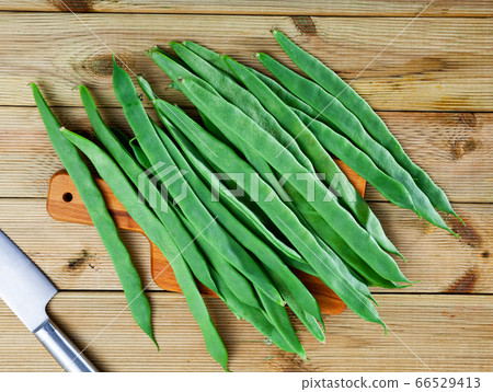 Fresh green beans on wooden surface in home kitchen 66529413