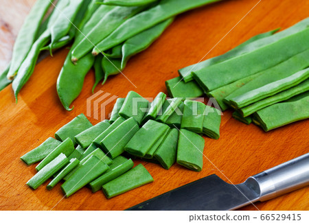 Sliced green beans on a wooden board Sliced green beans on a wooden board 66529415