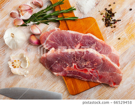 Close up of raw pork's fillet shoulder with garlic and rosemary Close up of raw pork's fillet shoulder with garlic and rosemary 66529458