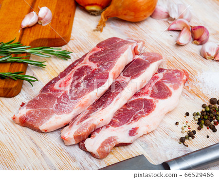 Cooking raw pork shoulder on wooden kitchen table Cooking raw pork shoulder on wooden kitchen table 66529466