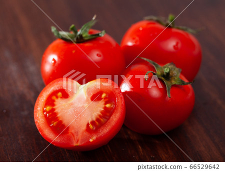 Cut fresh tomatoes on wooden table in home kitchen Cut fresh tomatoes on wooden table in home kitchen 66529642