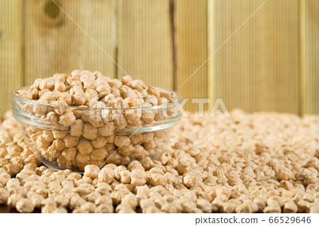 Glass jar with boiled chickpeas and bowl of raw chickpea grains on wooden surface Glass jar with boiled chickpeas and bowl of raw chickpea grains on wooden surface 66529646