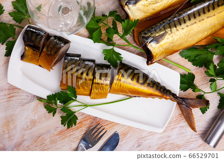 Sliced appetizing smoked mackerel with parsley closeup Sliced appetizing smoked mackerel with parsley closeup 66529701