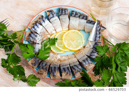 Tasty healthy smoked mackerel with parsley and lemon on the dining table 66529703