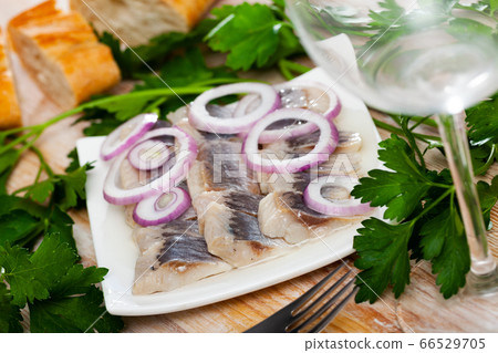 Marinated herring with sliced onion and parsley 66529705
