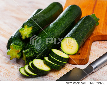 Whole and sliced fresh zucchini on wooden table Whole and sliced fresh zucchini on wooden table 66529922