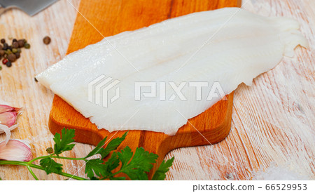 Fillet of raw halibut fish before cooking on wooden background Fillet of raw halibut fish before cooking on wooden background 66529953