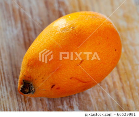 Closeup of whole ripe yellow loquat on wooden table. Vitamin fruits 66529991