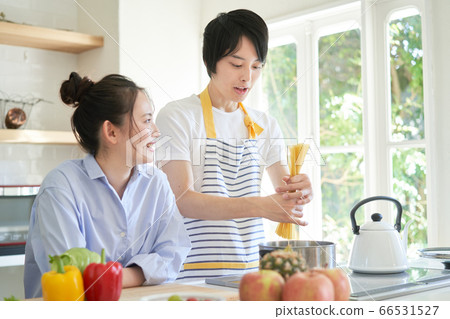 Men boiling spaghetti 66531527