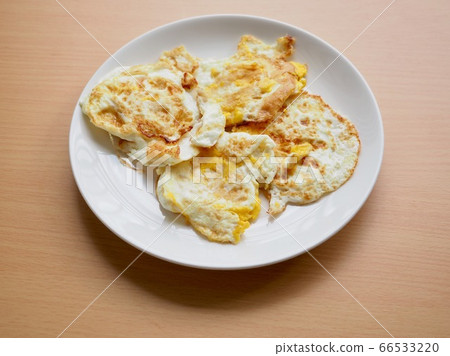 Fried eggs on a white porcelain plate Fried eggs on a white porcelain plate 66533220