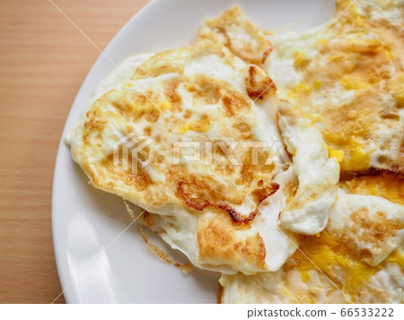 Fried eggs on a white porcelain plate Fried eggs on a white porcelain plate 66533222