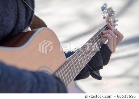 Musician playing guitar on the street 66533656