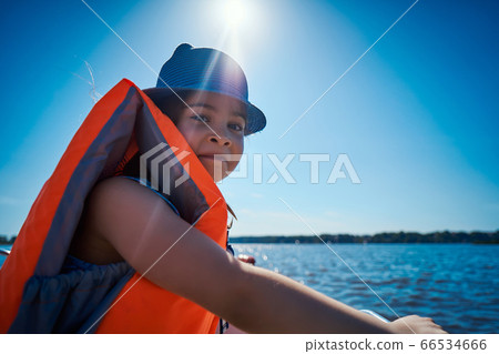 little girl in a swimming vest sits in a motorboat little girl in a swimming vest sits in a motorboat 66534666