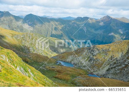 Breathtaking landscape in Carpathian mountains. With high green hills, rocks and small lakes Breathtaking landscape in Carpathian mountains. With high green hills, rocks and small lakes 66535651