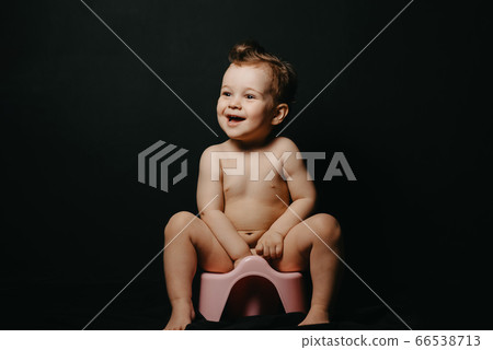 happy baby boy sitting on a potty and laughing happy baby boy sitting on a potty and laughing 66538713