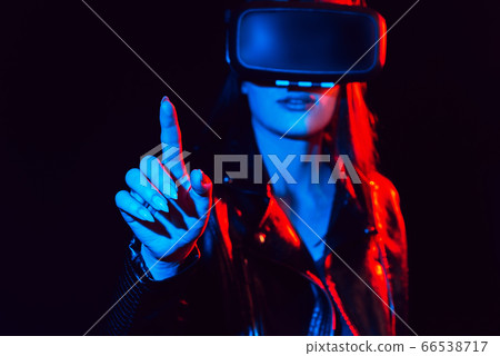 girl in 3D virtual reality glasses touches the projection screen with her finger girl in 3D virtual reality glasses touches the projection screen with her finger 66538717