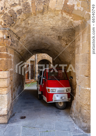 a small truck on the street of an old Italian town 66540749