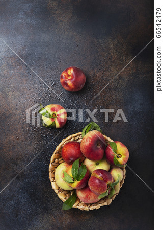 Top down view of sweet peaches with green leaves 66542479