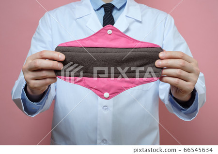 Male gynecologist holding reusale menstrual pads Male gynecologist holding reusale menstrual pads 66545634
