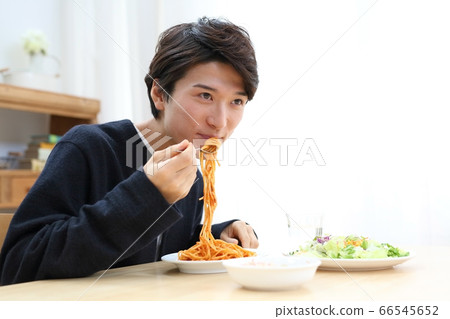 Image of young man eating at home 66545652