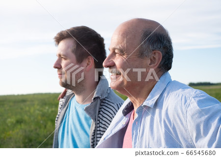 Mature caucasian father and his son looking aside 66545680