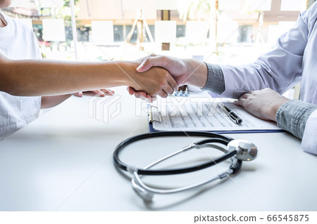 Doctor and patient shaking hands after a good and 66545875