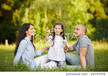 happy family with child girl blow soap bubbles happy family with child girl blow soap bubbles 66545956
