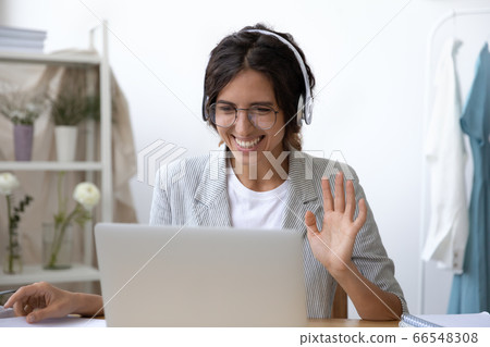 Smiling woman in headset talk on video call on laptop Smiling woman in headset talk on video call on laptop 66548308