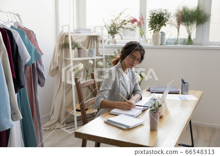 Caucasian female designer work on laptop making notes Caucasian female designer work on laptop making notes 66548313