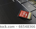High capacity memory card on laptop close-up. SDXC 256 gb. Modern storage devices concept. Top angle view. Keyboard buttons in frame. Selective focus. 3D render 66548366
