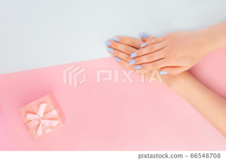 Beautiful woman manicure on creative trendy pink background with gift box Beautiful woman manicure on creative trendy pink background with gift box 66548708