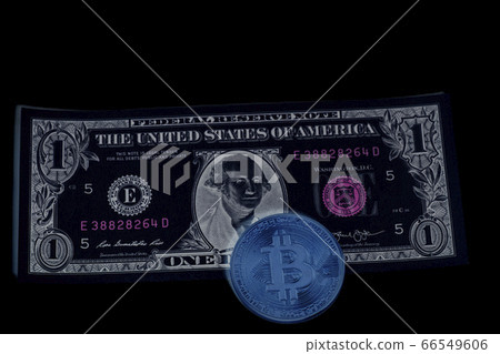 Bitcoin coin on one U.S. dollar banknote on black 66549606