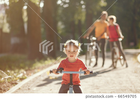 Family with a bicycle in a summer park 66549705