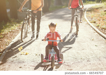 Family with a bicycle in a summer park 66549707