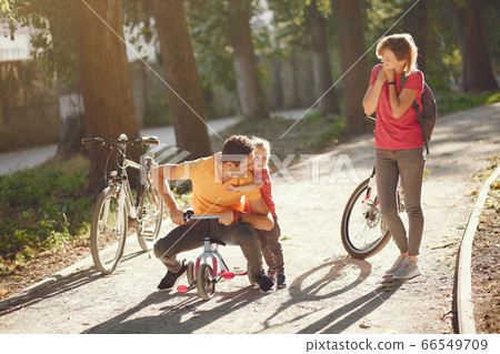 Family with a bicycle in a summer park 66549709
