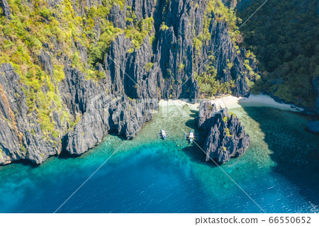 El Nido, Palawan, Philippines, aerial view of boats and rocky mountains scenery at Secret Lagoon beach El Nido, Palawan, Philippines, aerial view of boats and rocky mountains scenery at Secret Lagoon beach 66550652