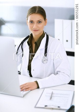 Doctor typing on pc computer while sitting at the desk in hospital office. Physician woman at work. Data in medicine and healthcare 66551291