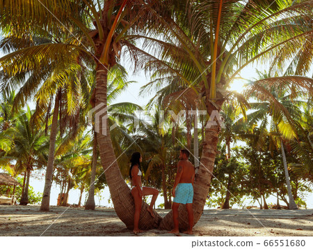 Lovely couple relaxing at the white sandy beach with palm trees in Onok Island in Balabac Palawan Lovely couple relaxing at the white sandy beach with palm trees in Onok Island in Balabac Palawan 66551680
